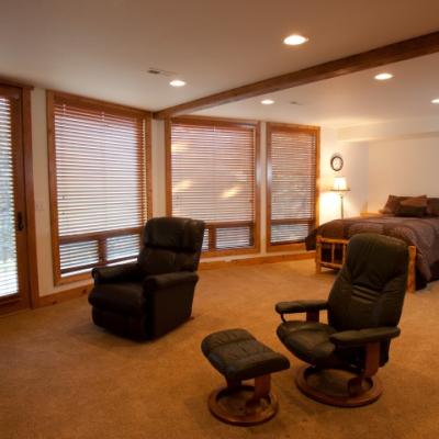 Master bedroom with window wall, door to outside and sitting area to watch television