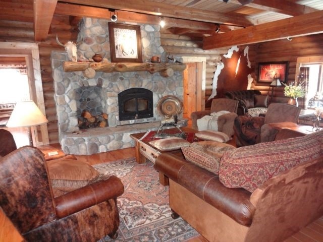 Living room of log home with large rock fireplace