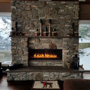 Beautiful rock fireplace with fire burning