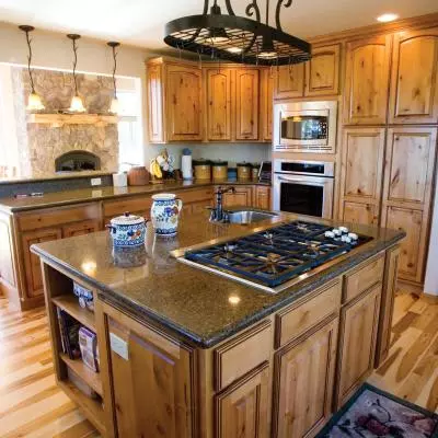 Looking from kitchen towards family room. Large island with large cooktop stove, vegetable sink, granite counters and alot of storage.