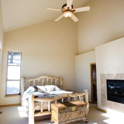 Master bedroom with vaulted ceiling, ceiling fan and gas fireplace.
