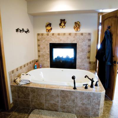 Soaking tub in master bath next to gas fireplace